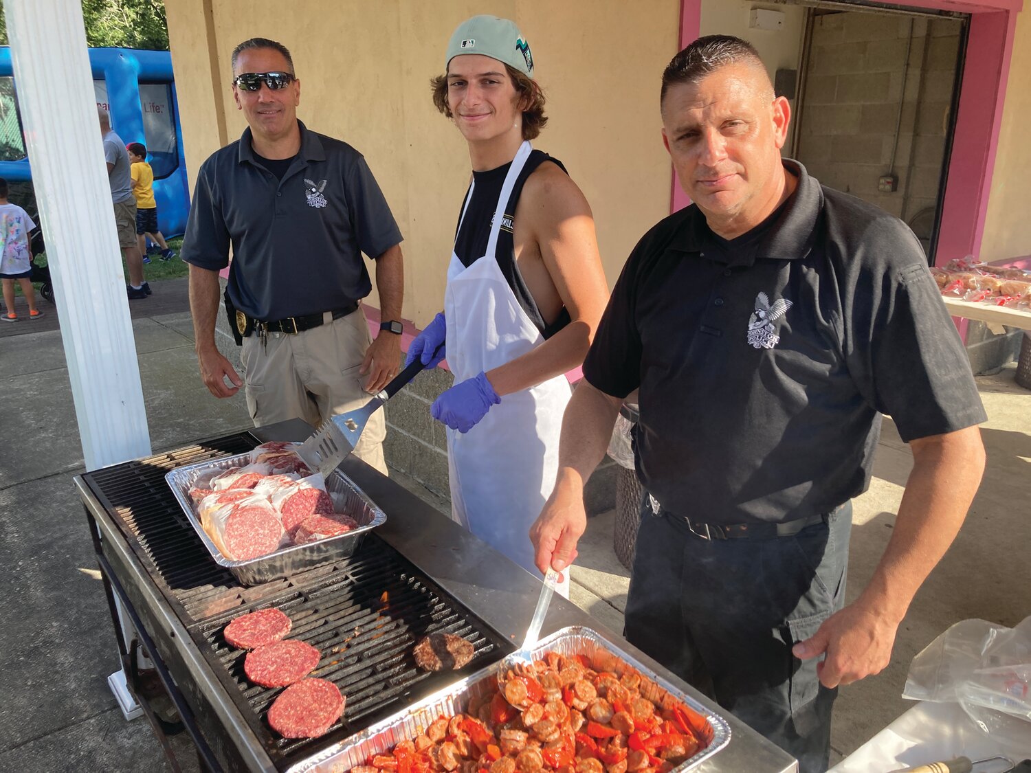 ON THE GRILL: Sgt. Luca Lancelotti, Mike Psilopoulos, and his father, Officer Charles Psilopoulos helped man the grills that were busy all evening.